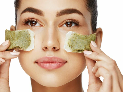 Using cooled tea bags to soothe puffy eyes and dark circles